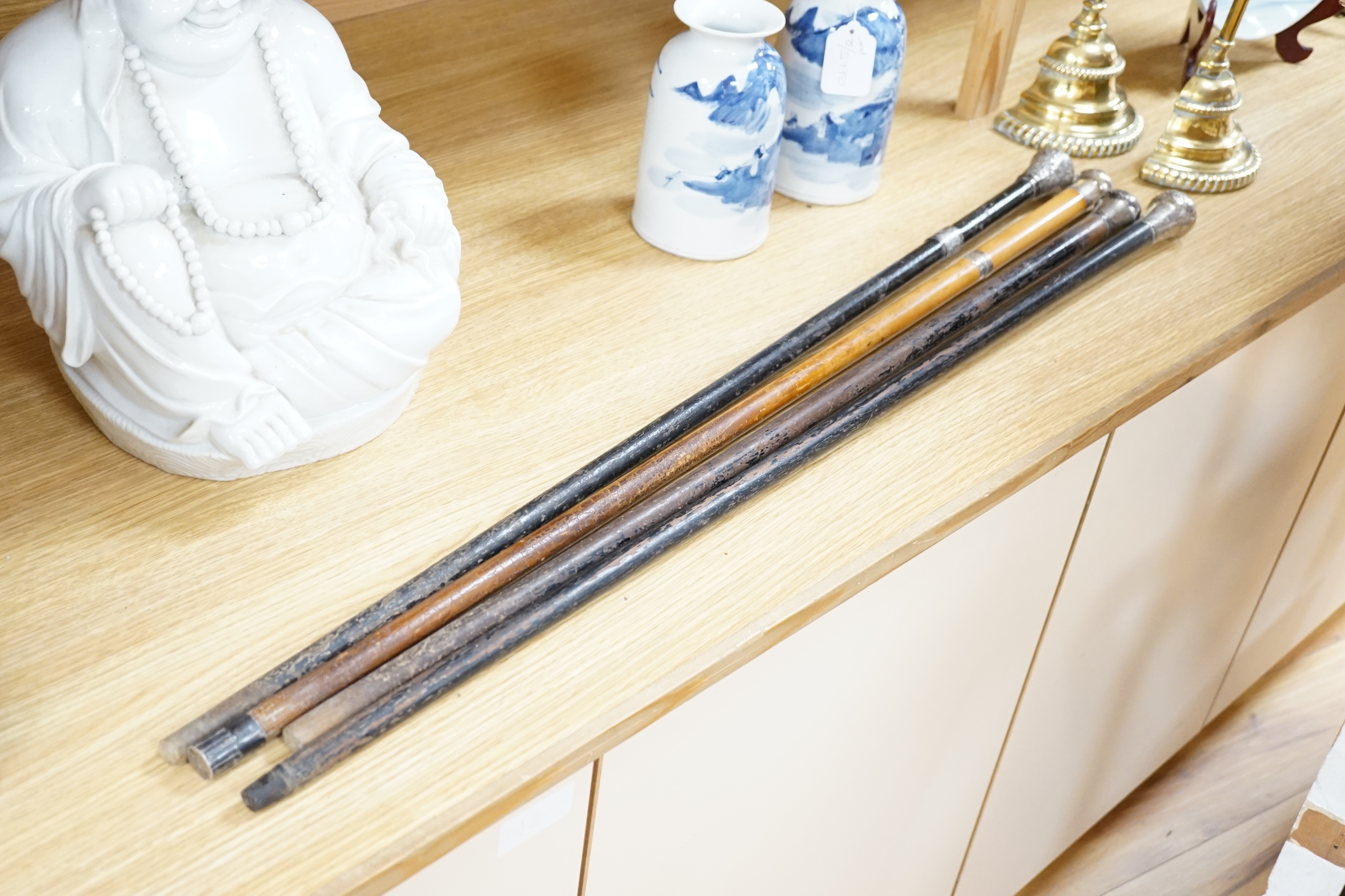 Four Victorian silver mounted handled walking sticks: one being a sword stick, sword stick 90cm long